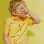 photo of a boy covering his eyes