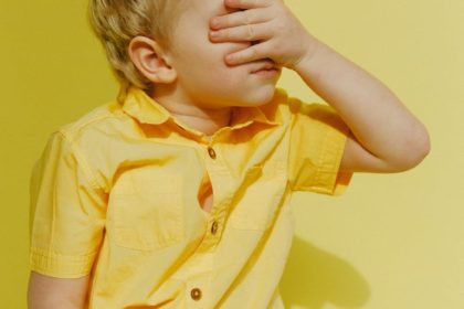 photo of a boy covering his eyes