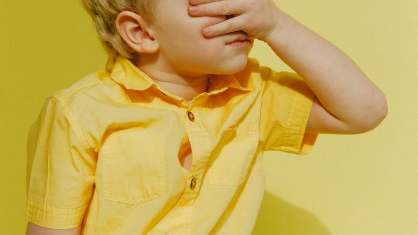 photo of a boy covering his eyes